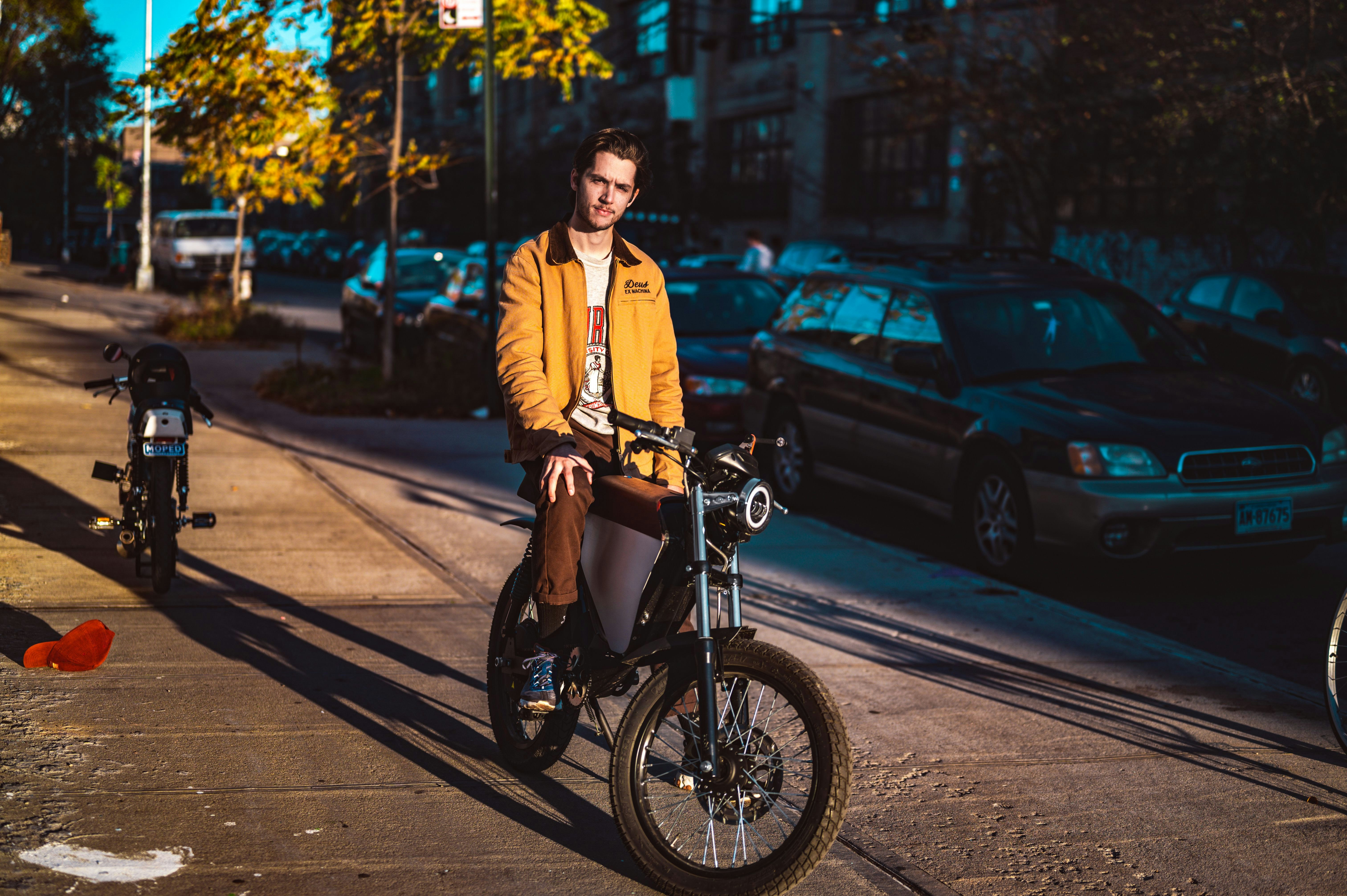 woman in yellow jacket and black pants riding on black motorcycle during daytime